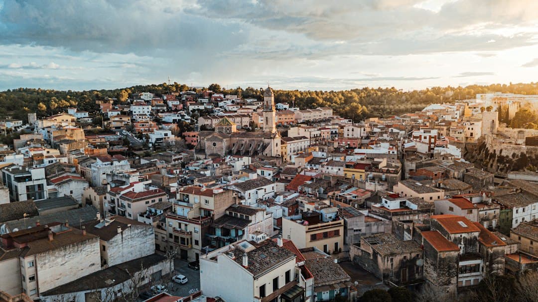 Vista aérea de un pueblo con tejados y cielo anaranjado, en el chat de El Catllar