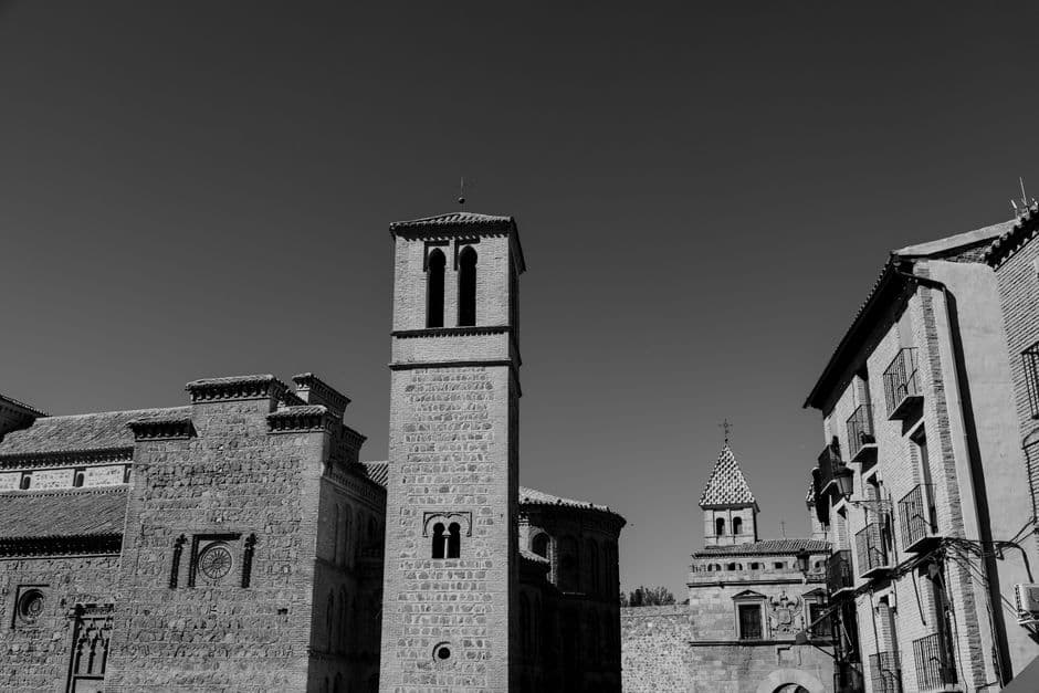 Calle empedrada con arquitectura medieval y una catedral al fondo, en el chat de Miengo