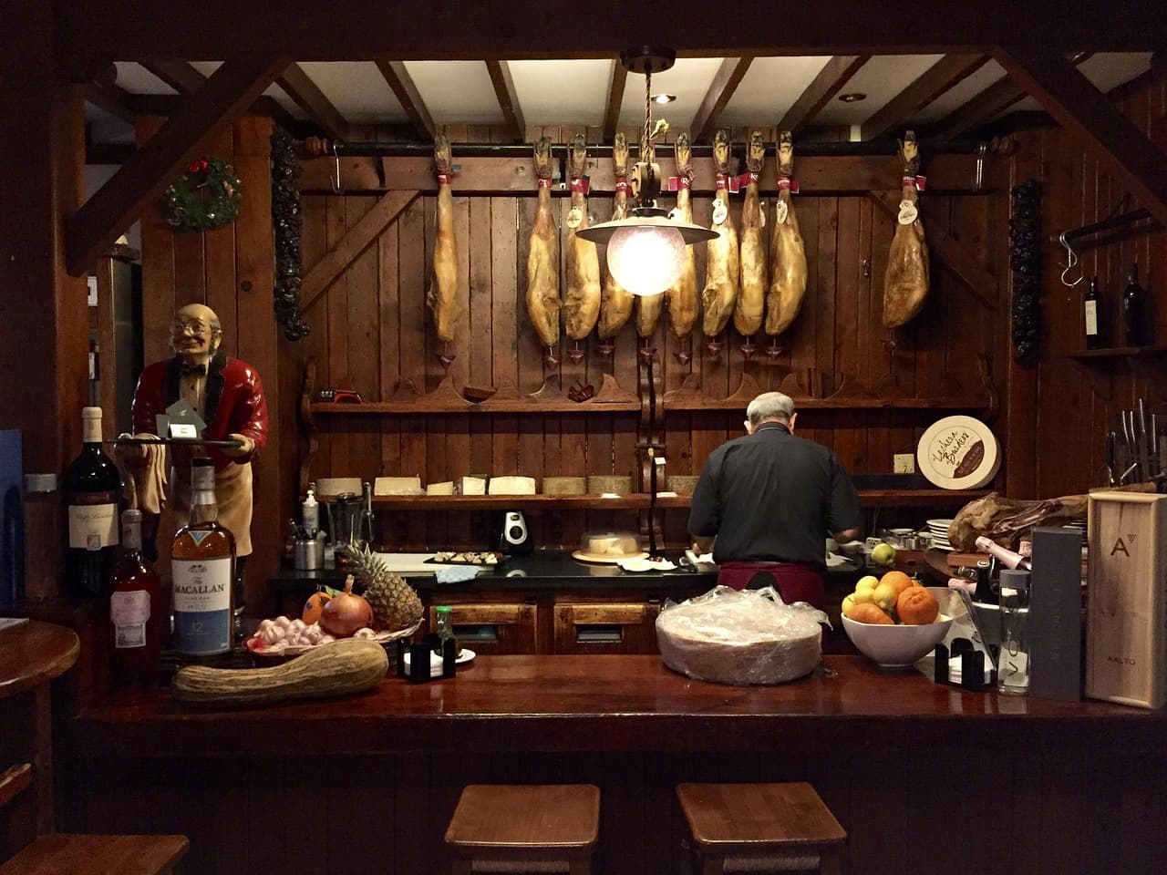 Barra de restaurante español con jamón y platos típicos, en el chat de Quesada