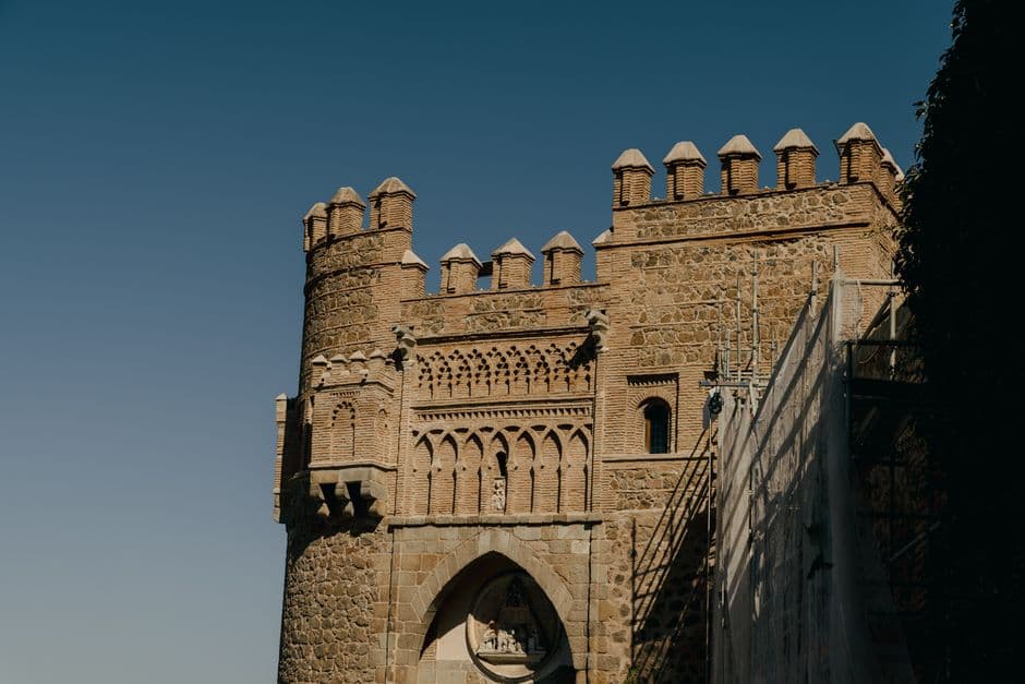 Puerta medieval con arco y almenas, vista en esquina, en el chat de Villanueva del Rosario