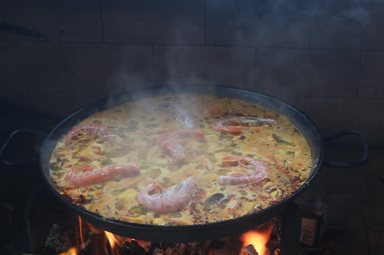 Paella y fideuá al fuego con vaso de bebida, en el chat de Camarles