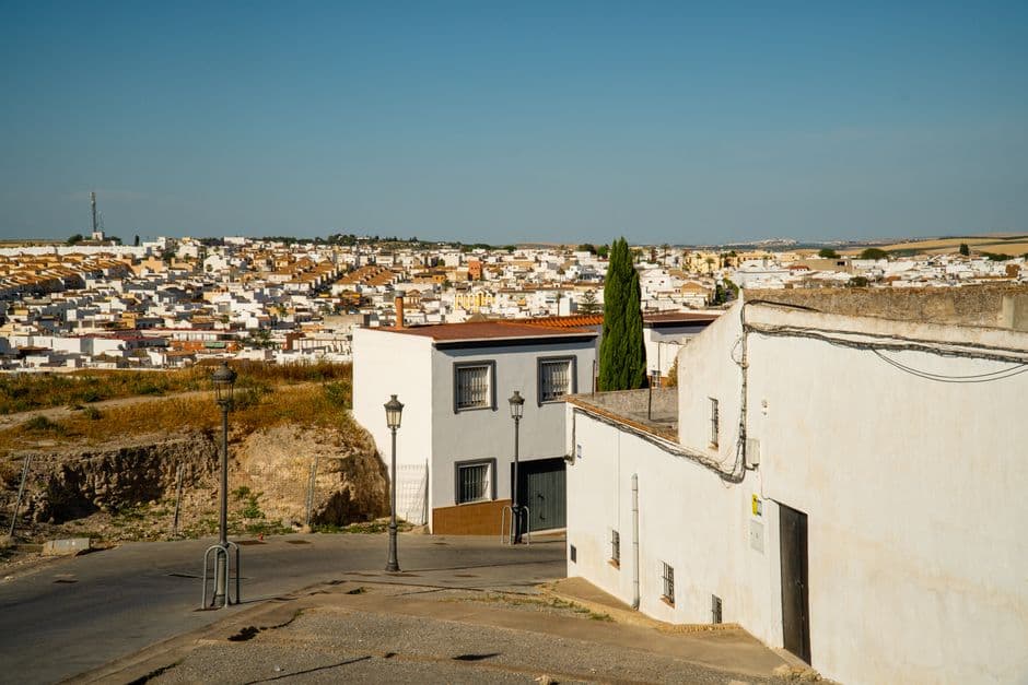 Casas blancas con tejados rojos en calle cielo azul, en el chat de Huévar del Aljarafe