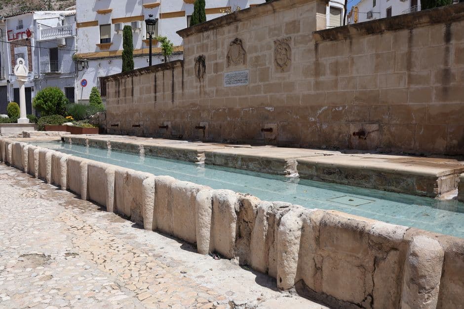 Fuente histórica de piedra con agua corriendo en Martos, Andalucía, en el chat de Benalúa