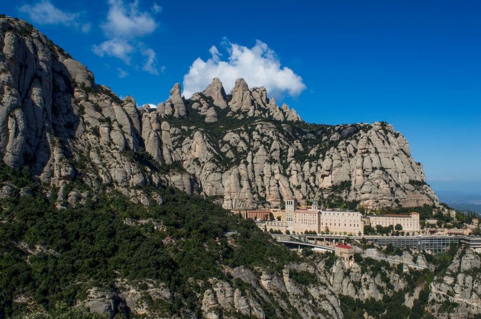 Cimas rocosas y bosques verdes bajo nubes, vista aérea, en el chat de Monistrol de Montserrat