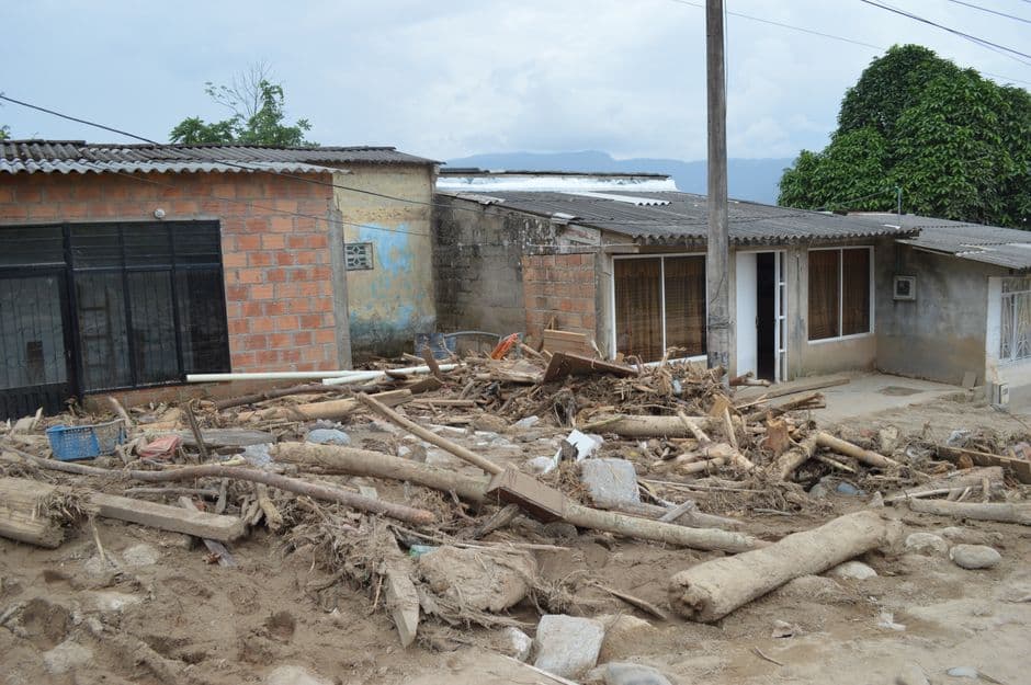 Troncos de madera tendidos junto a casas de un pueblo, en el chat de Riosucio