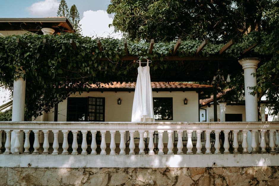 Vestido blanco colgado en una enramada de madera, en la sala de chat de Villa Elisa