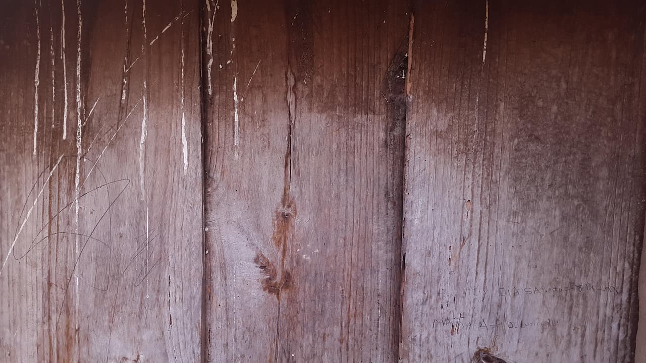 Puerta de madera pintada de rosa con detalles envejecidos, en el chat de Morazán