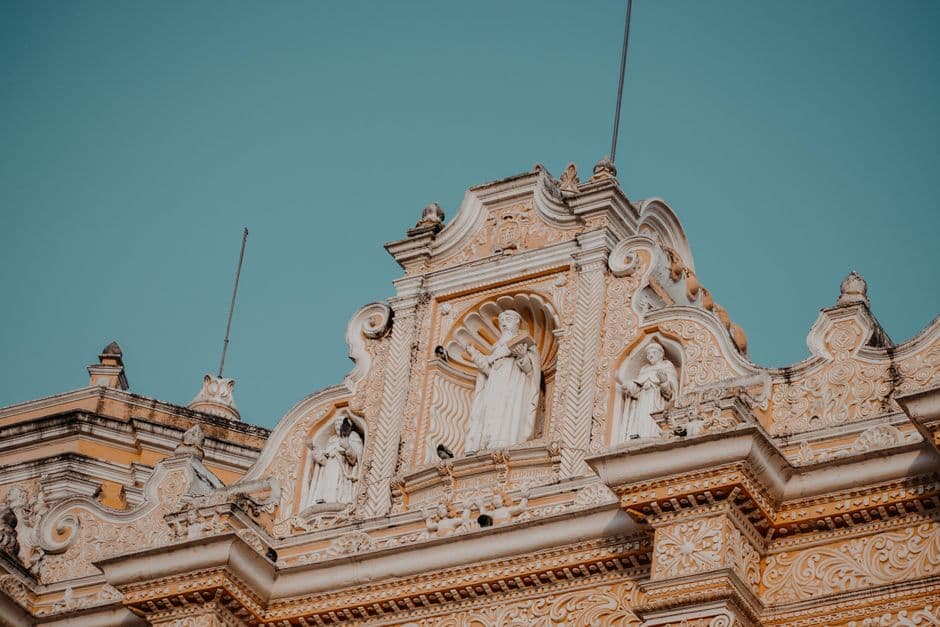 Iglesia marrón con estatuas bajo un cielo azul, en el chat de La Democracia