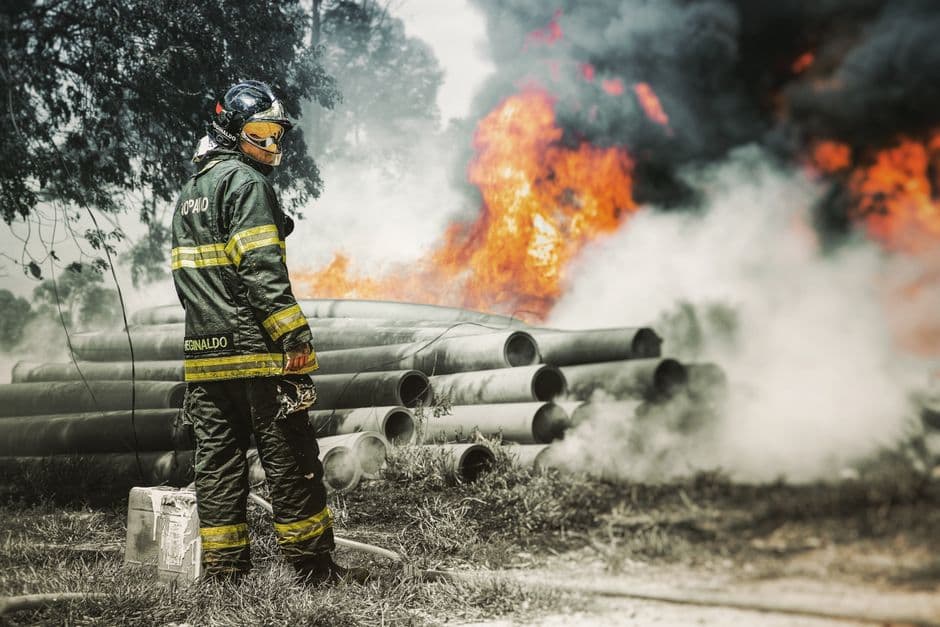 Bombero en uniforme de pie junto a un incendio, en la sala de chat de Cotia