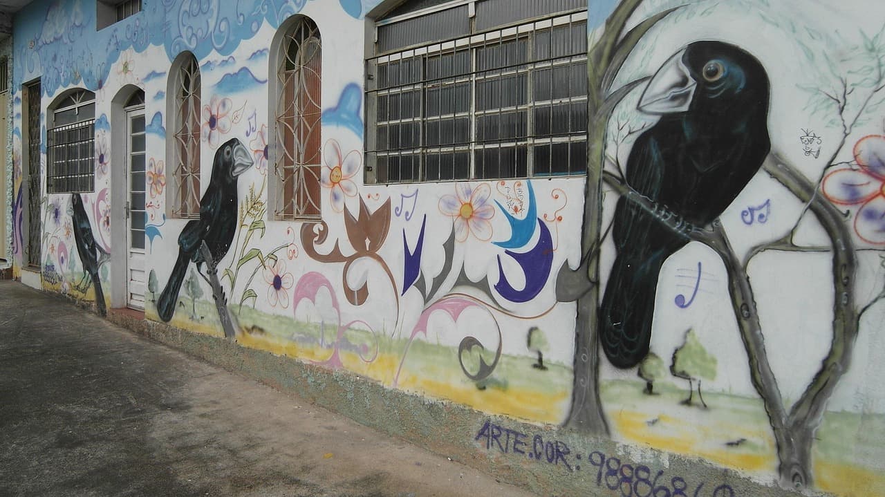 Mural colorido con figuras y letras en pared urbana, en el chat de Embu das Artes
