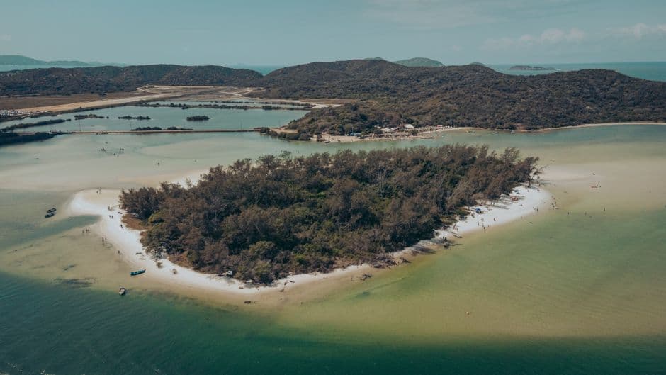 Isla rocosa rodeada de aguas turquesas y arena, en la sala de chat de Araruama
