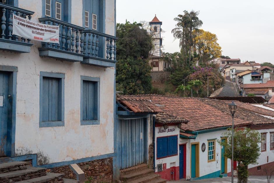 Calle empedrada con casas coloniales y una iglesia barroca, en la sala de chat de Sabará