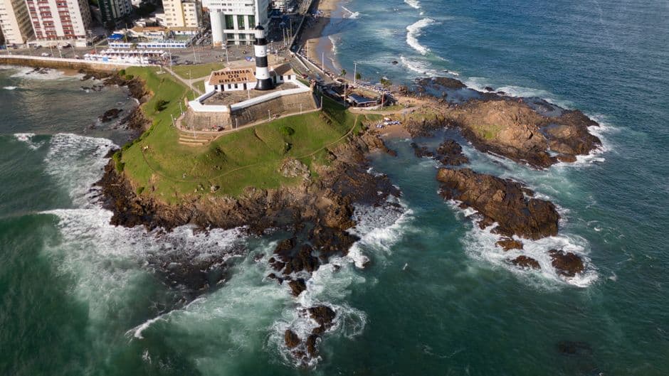 Faro de Barra en la costa de Salvador, bajo cielo azul, en el chat de Barbacena