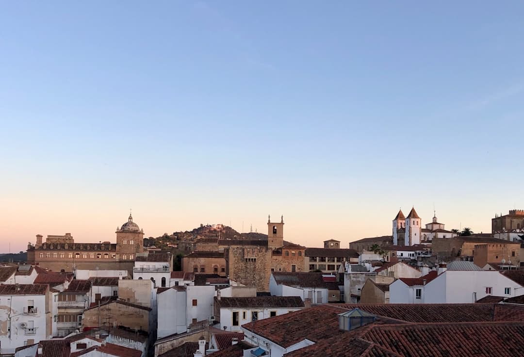 Edificios de concreto marrón y blanco bajo cielo azul, en la sala de chat de Extremadura