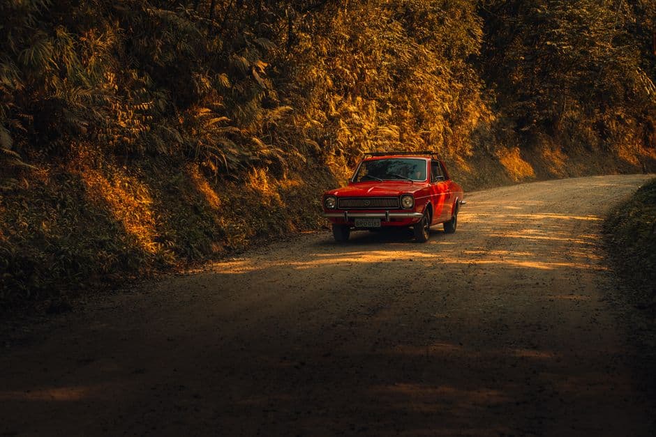 Coche rojo circulando por un camino de tierra en el bosque, en el chat de Ribeirão Pires