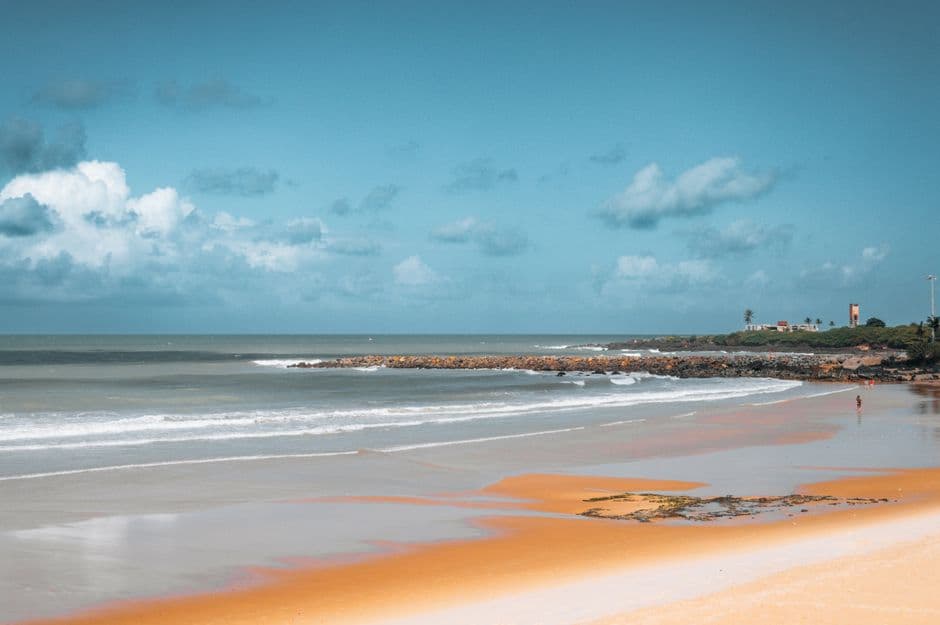 Playa de arena blanca y olas bajo cielo azul, en la sala de chat de Santana