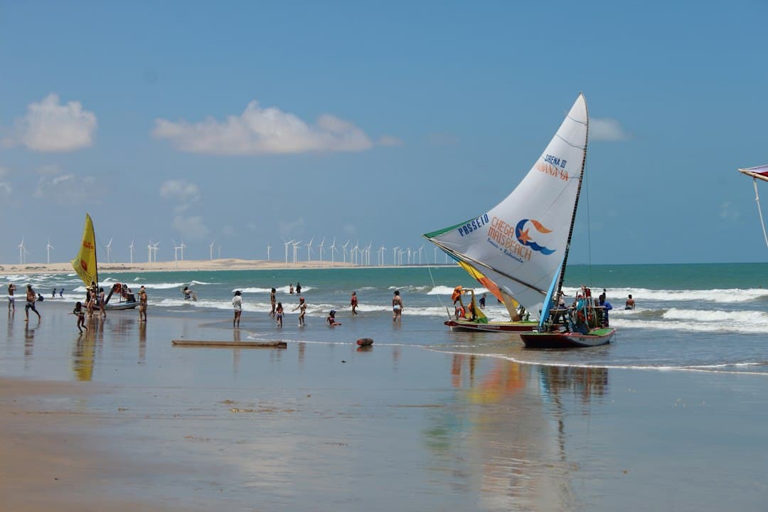 Veleros en una playa con aerogeneradores al fondo, en el chat de Maranguape