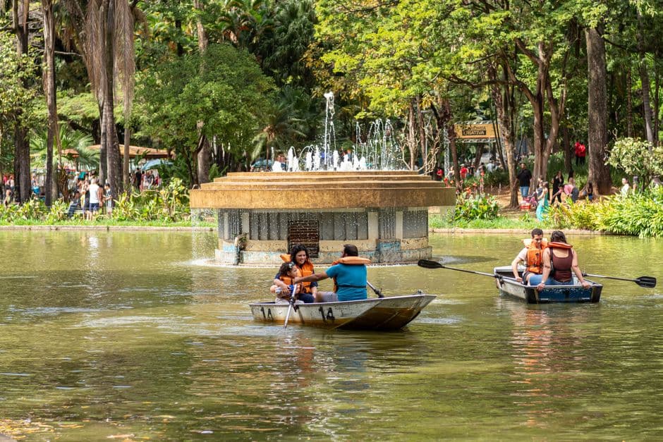 Barca navega en lago de parque urbano con árboles, en la sala de chat de Poá