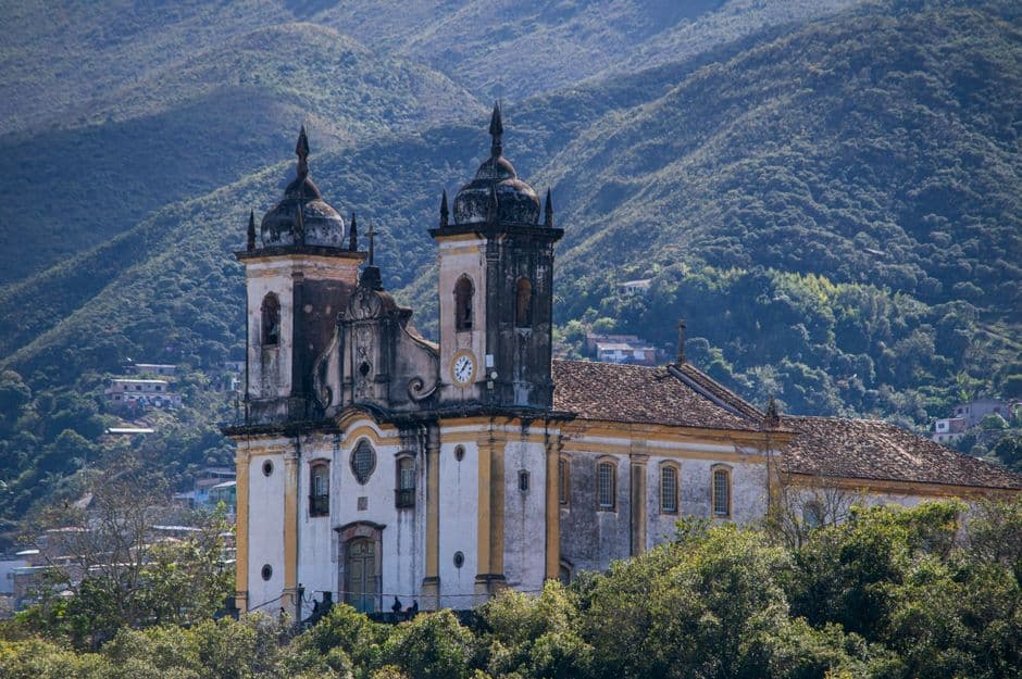 Iglesia barroca histórica rodeada de vegetación montañosa, en el chat de Assis