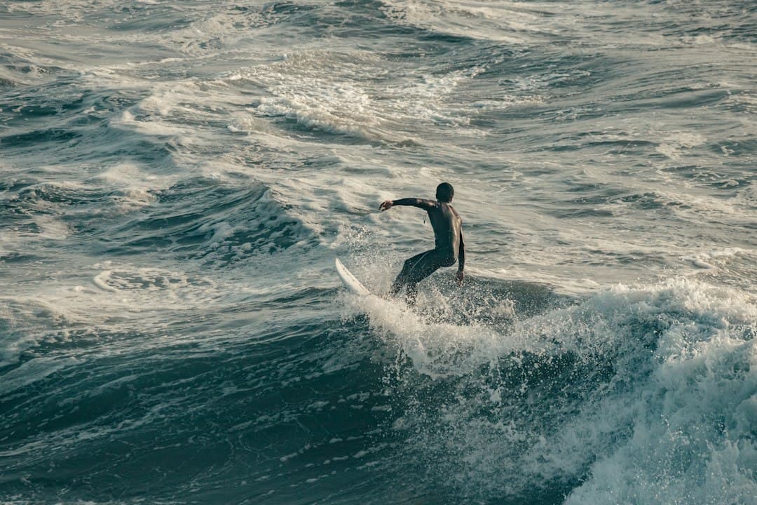 Un hombre surfea una ola grande sobre su tabla, en la sala de chat de Huntington