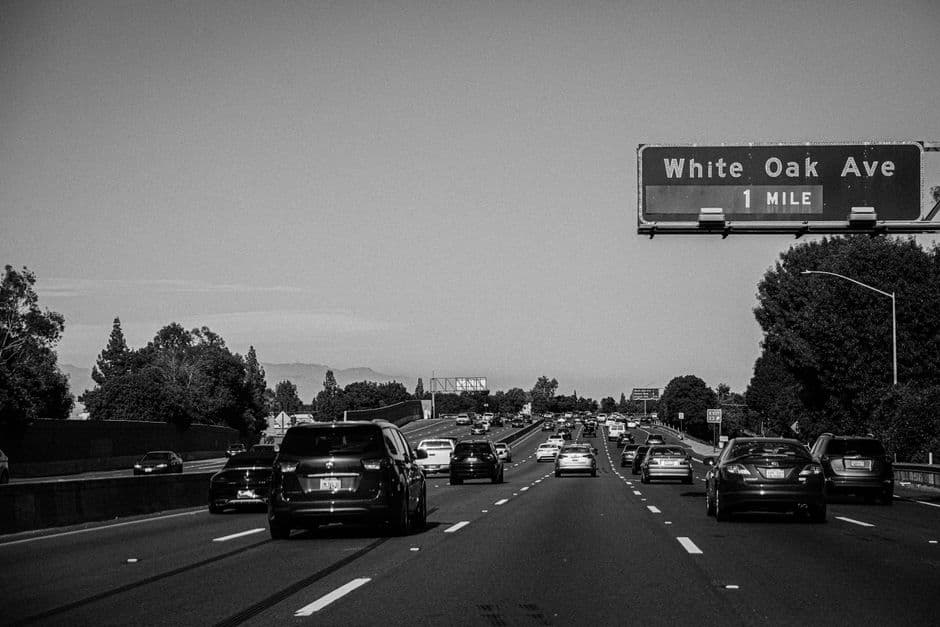 Coches en una autopista en escala de grises, con un cartel de la carretera, en el chat de Thousand Oaks