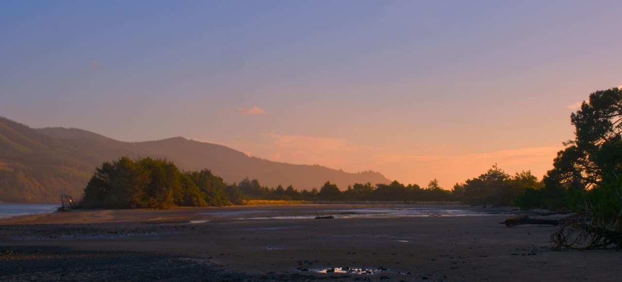 Costa y montañas al atardecer con luz dorada, en el chat de Gresham