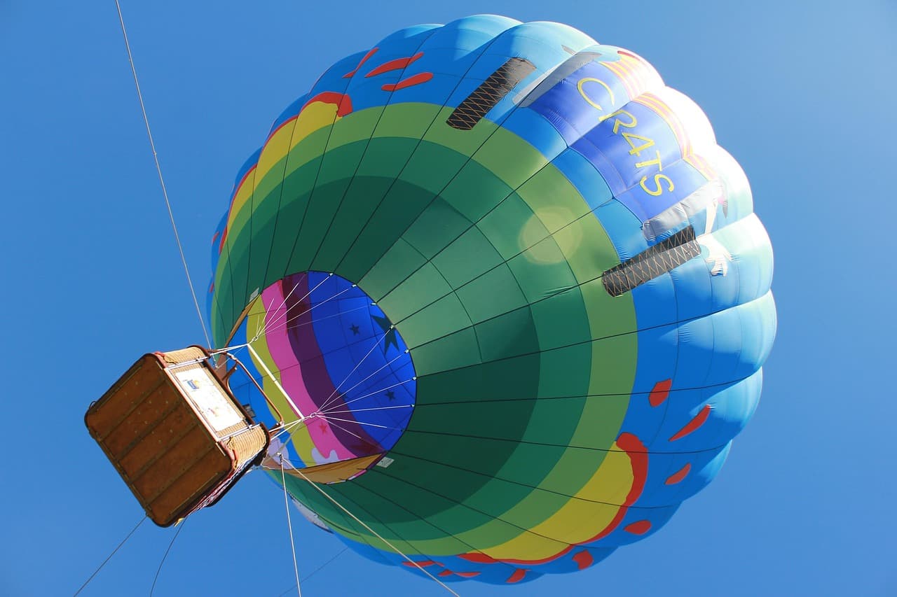 Globo aerostático colorido sobre paisaje abierto bajo cielo azul, en la sala de chat de Temecula