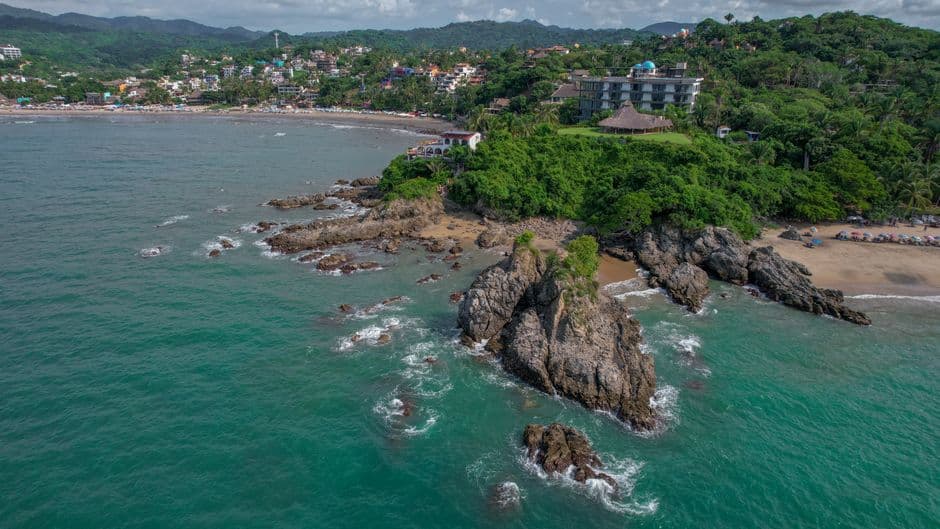 Vista aérea de la playa y el mar bajo cielo claro, en el chat de Nayarit