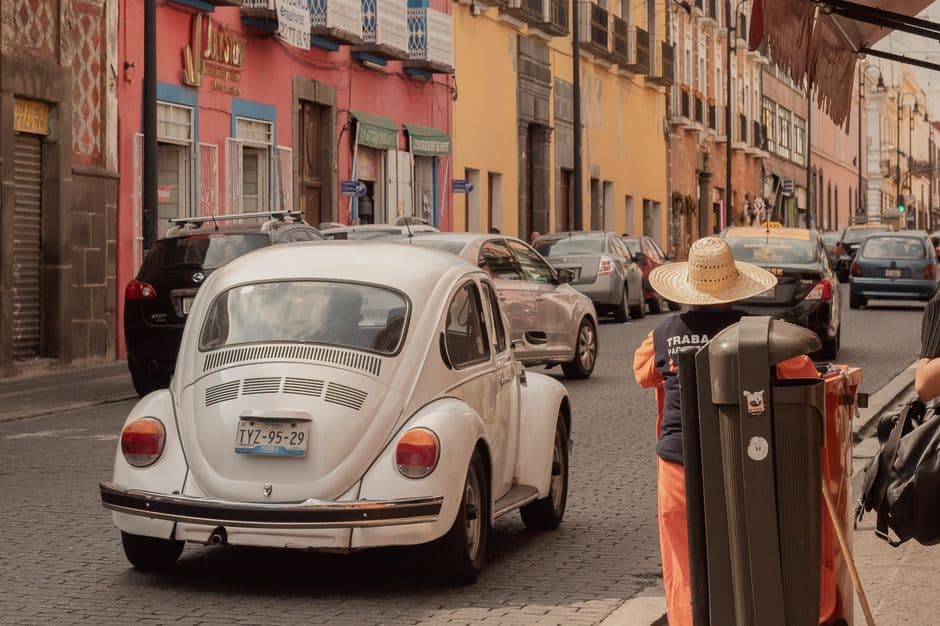 Escarabajo blanco de Volkswagen circulando por calle de Puebla, en el chat de Puebla