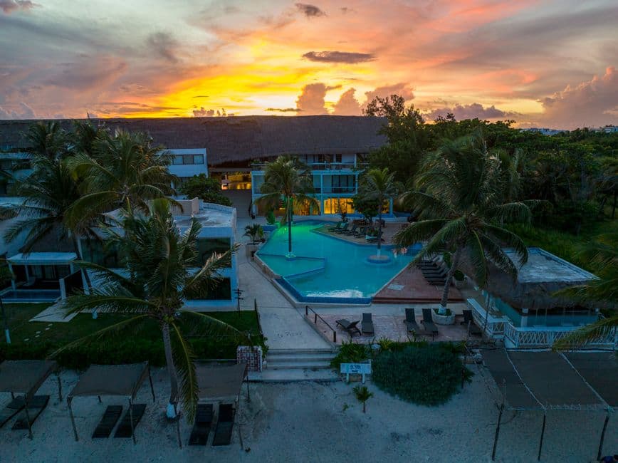 Atardecer sobre piscina y playa del resort, en el chat de Quintana Roo