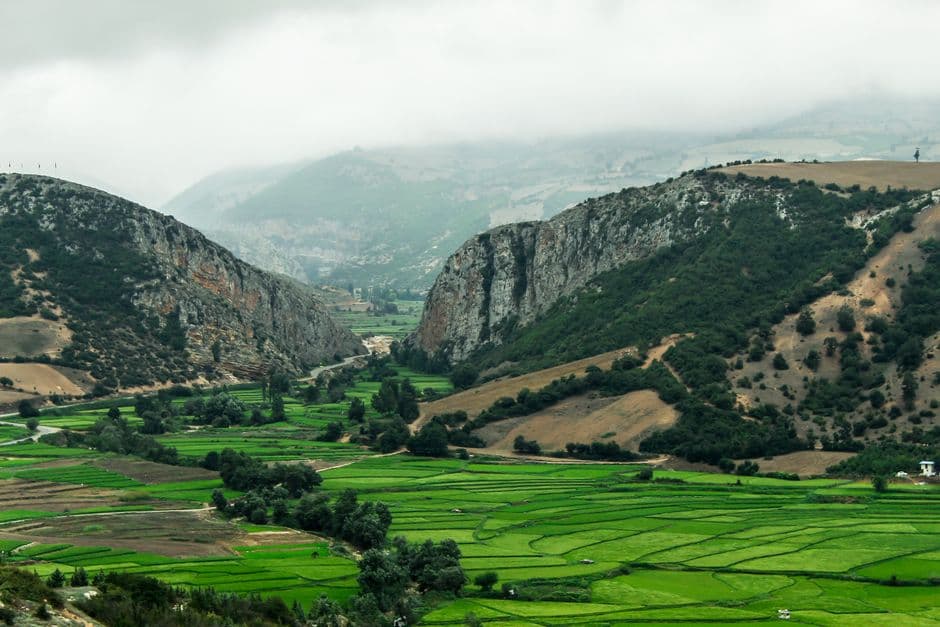 Campo verde con montañas bajo nubes blancas, en el chat de San Juan