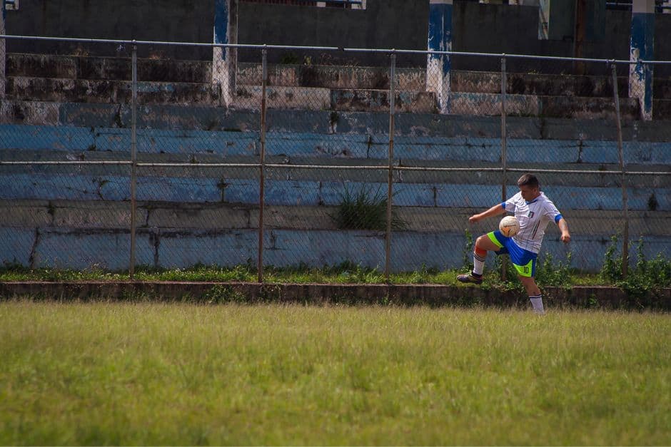 Hombre jugando al fútbol en un campo de hierba verde, en el chat de Los Guayos