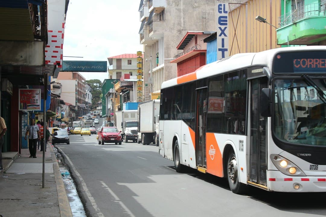 Autobús circulando por una calle junto a edificios altos, en el chat de Las Cumbres