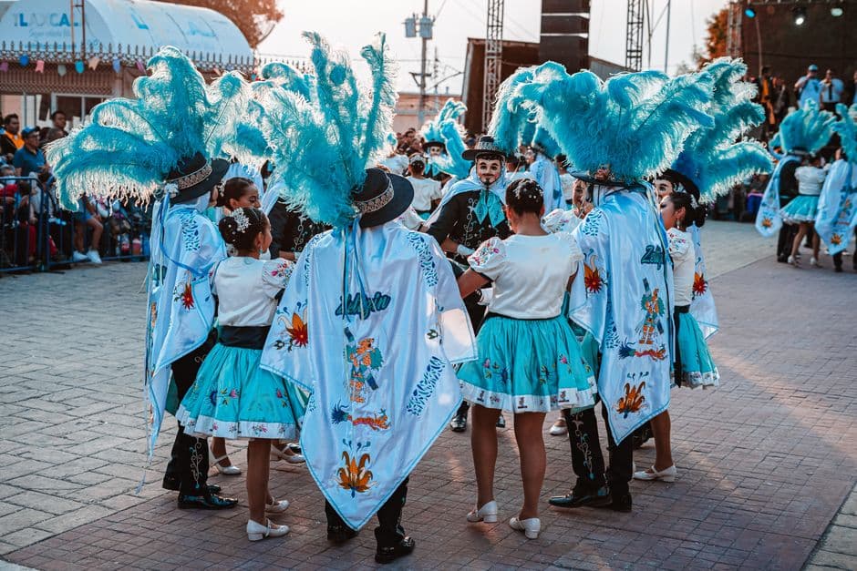 Grupo de bailarines con trajes turquesa actuando juntos, en la sala de chat de Tlaxcala