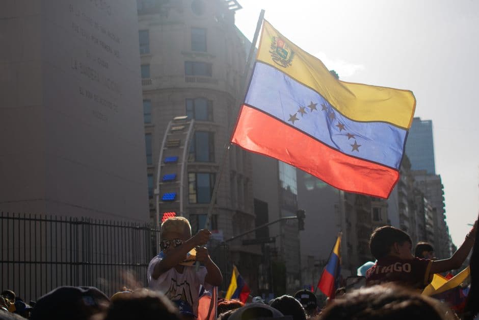 Bandera venezolana ondeando en una protesta en la calle, en el chat de Libertador