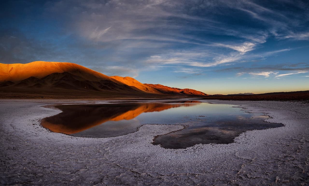 Lago de un salar rodeado de montañas, en el chat de Vitacura