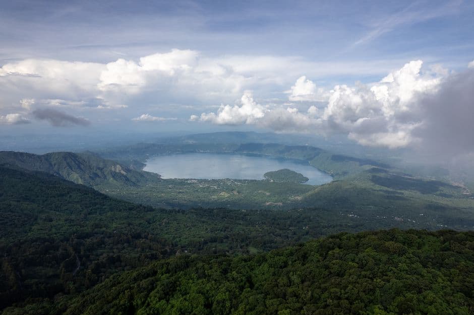 Vista aérea del lago Coatepeque con aguas azules y montañas alrededor, en el chat de Coatepeque