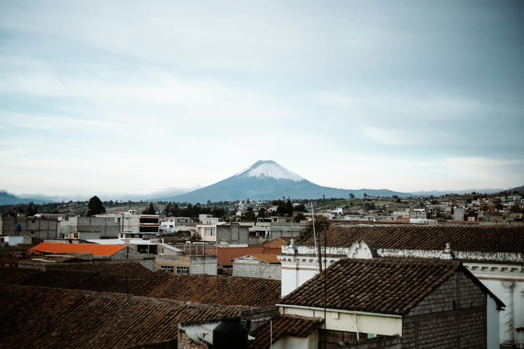 Ciudad con edificios y calles bajo una montaña nevada, en la sala de chat de Latacunga