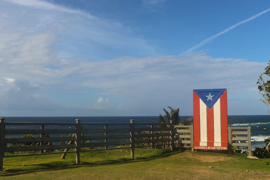 Bandera puertorriqueña sobre un paisaje costero, en el chat de Toa Baja