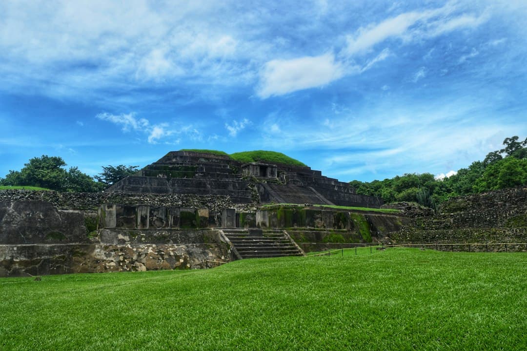 Amplio campo de hierba con un edificio al fondo, en el chat de Chalchuapa