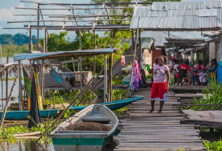 Mujer de pie junto a una barca, en el chat de Ciénaga de Oro