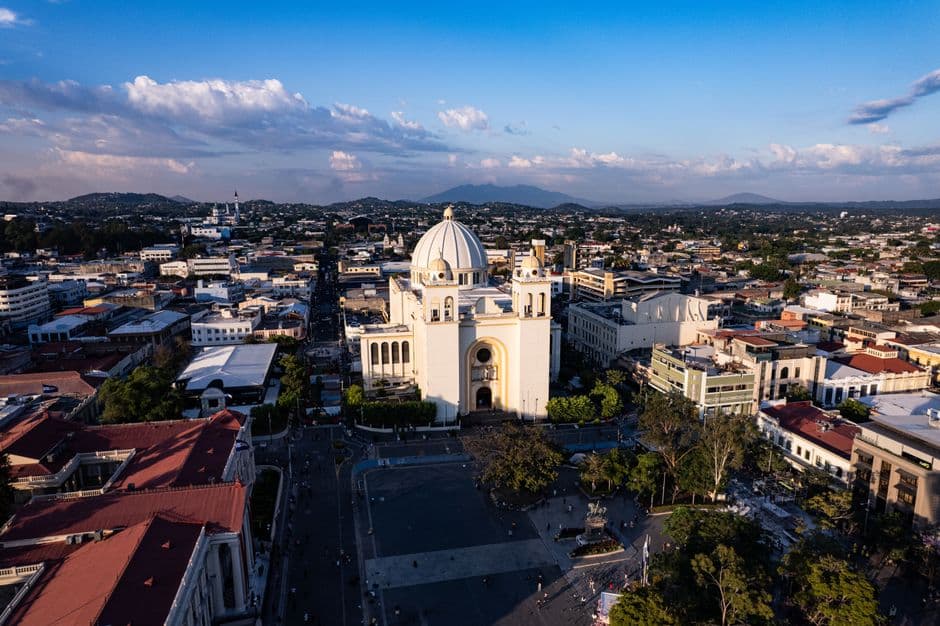 Catedral de San Salvador aérea al atardecer, luces doradas, en la sala de chat de Soyapango