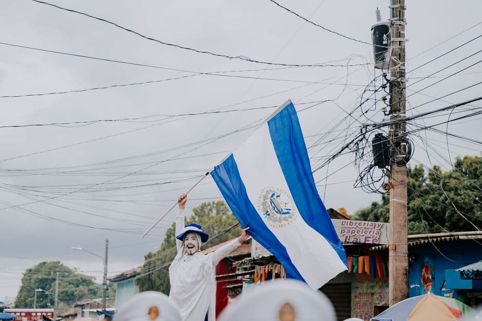 Hombre agitando bandera de El Salvador en la calle, en la sala de chat de Mejicanos