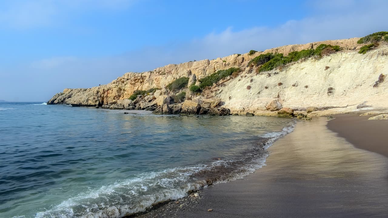 Olas rompiendo en la playa con montañas detrás, en el chat de Siquisique