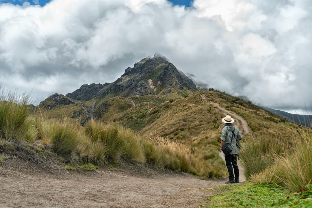 Hombre caminando por un camino de tierra junto a un campo verde, en el chat de El Triunfo