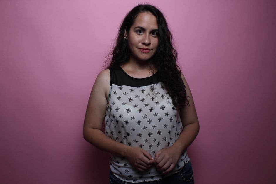 Mujer con top sin mangas posando sobre un fondo rosa, en el chat de Lambayeque