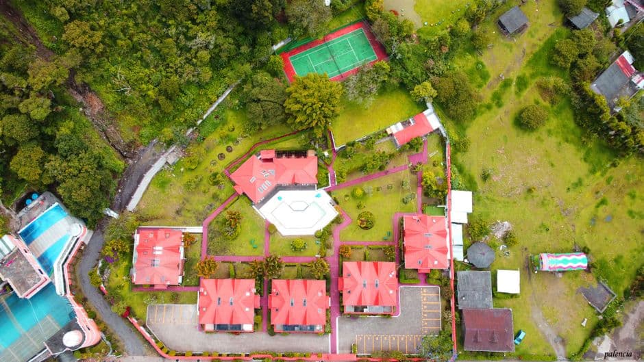 Vista aérea de tejados de casas entre campos verdes, en el chat de Santa Rosa