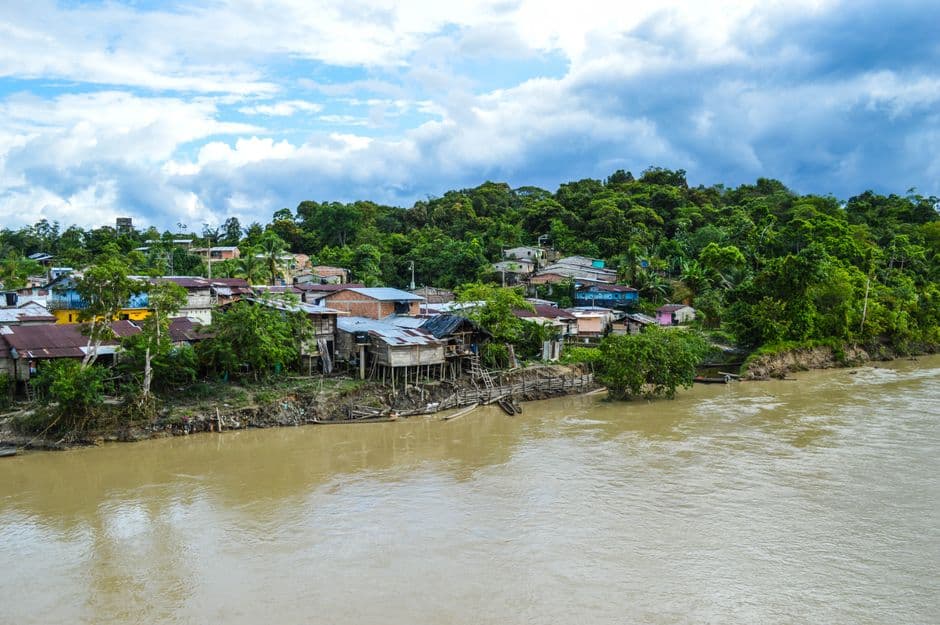 Casas junto a un río rodeadas de árboles verdes, en el chat de Puerto Libertador