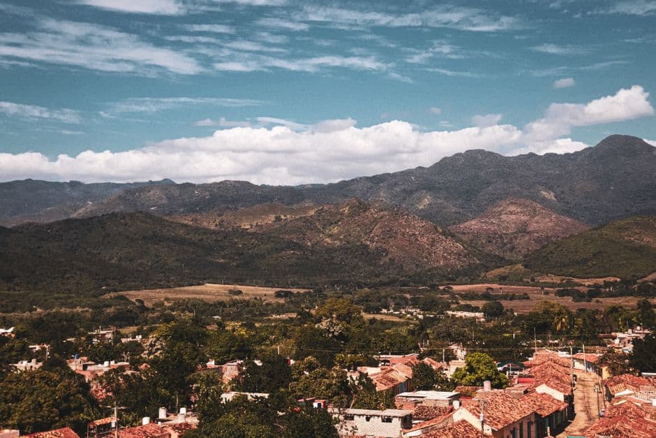 Vista aérea de casas y montañas bajo un cielo azul nublado, en el chat de San Manuel