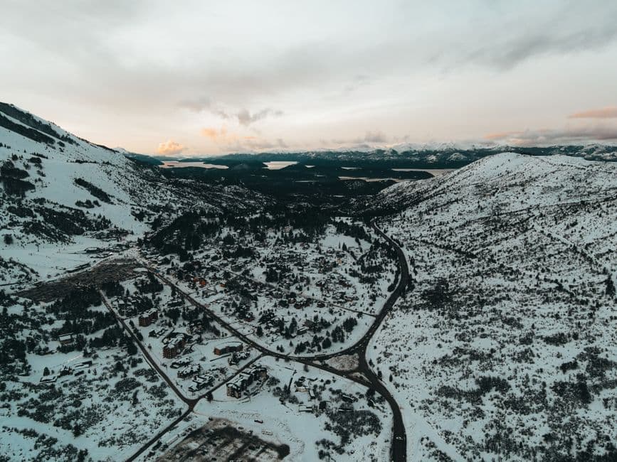 Vista aérea de montañas nevadas bajo un cielo nublado, en el chat de Villa Constitución
